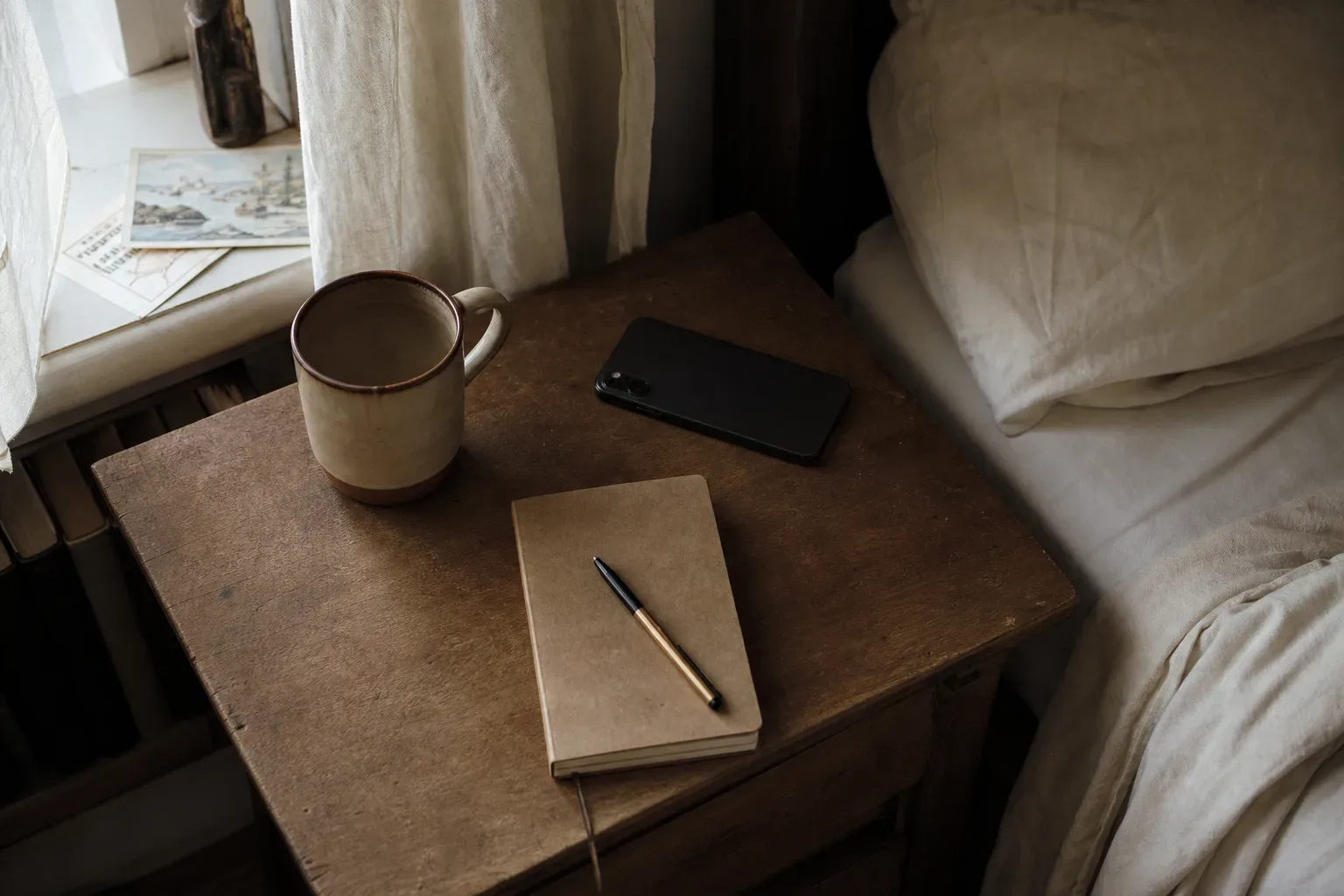 Quiet bedside table with phone and morning light