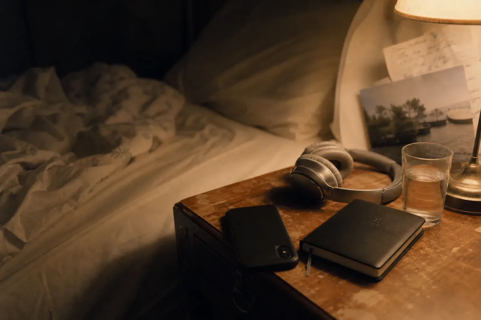 Bedside headphones beside a softly lit journal