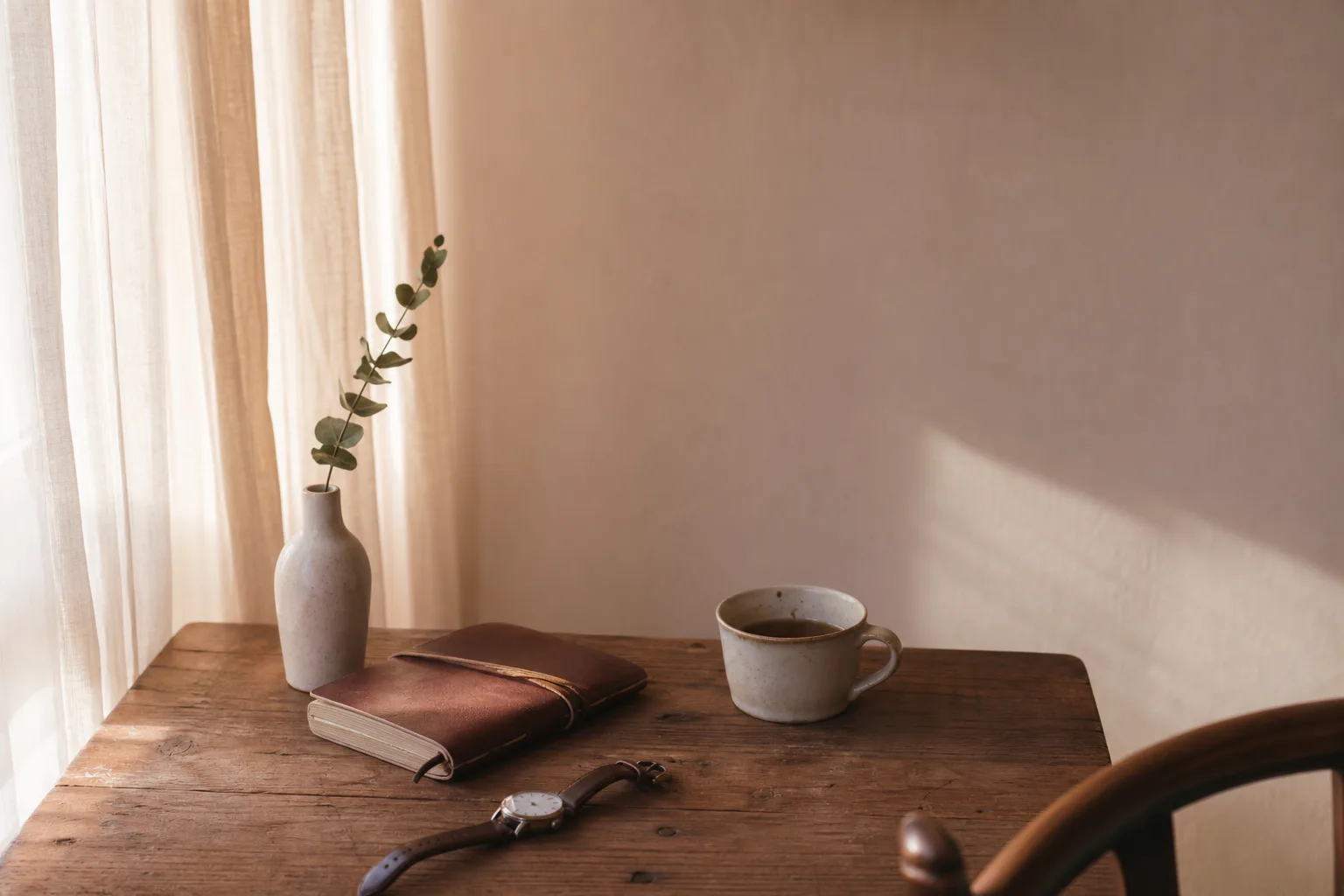 A diary page on a wooden table, a fountain pen across the spine, soft morning light from camera left.